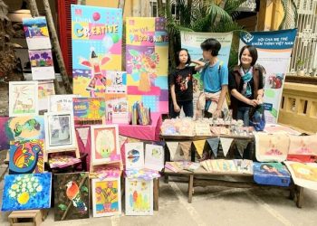 Chị Chử Thị Thanh Hướng giới thiệu những sản phẩm in tranh của trẻ khiếm thính. Ảnh NVCC