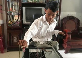 Ngọc Hiếu chăm chú sửa chữa máy tính cho khách hàng – Ảnh: NVCC