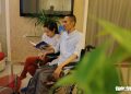 Nguyễn Chánh Tín ngồi xe lăn viết sách