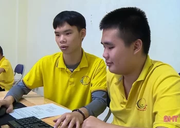 Em Lê Thế Duẩn (bên trái) hướng dẫn cho các em học sinh tại Trung tâm Hỗ trợ phát triển giáo dục trẻ khuyết tật Hồng Lĩnh trong giờ học tin học